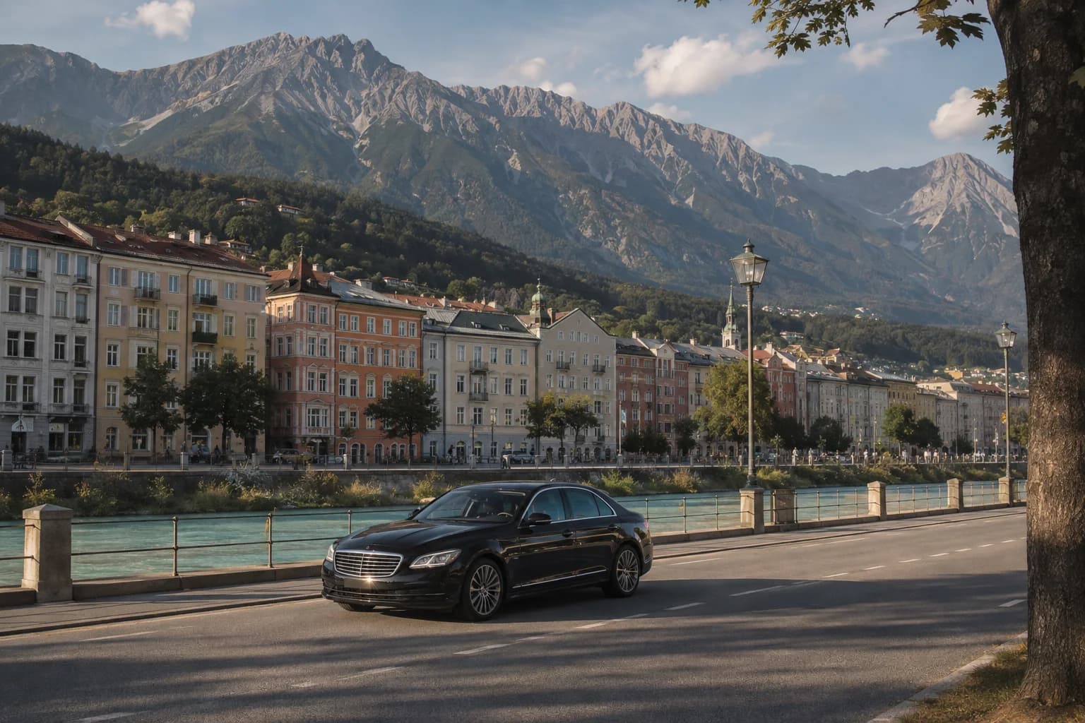 Eine schwarze Limousine vor bunten Häusern am Fluss und einer Alpenkulisse.